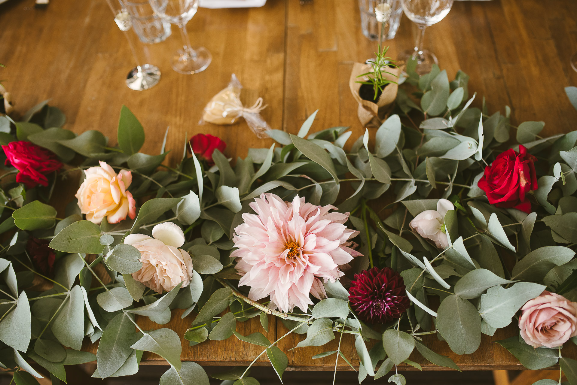 pastel flowers and eucalyptus leaves decorating a wedding table 