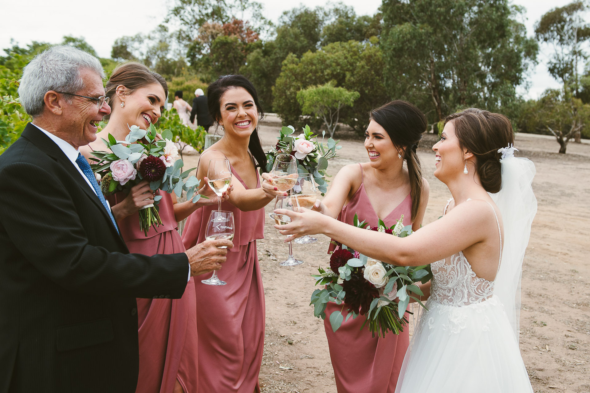 bridesmaids and bride and father enjoy a wine before the ceremony at beach road wines