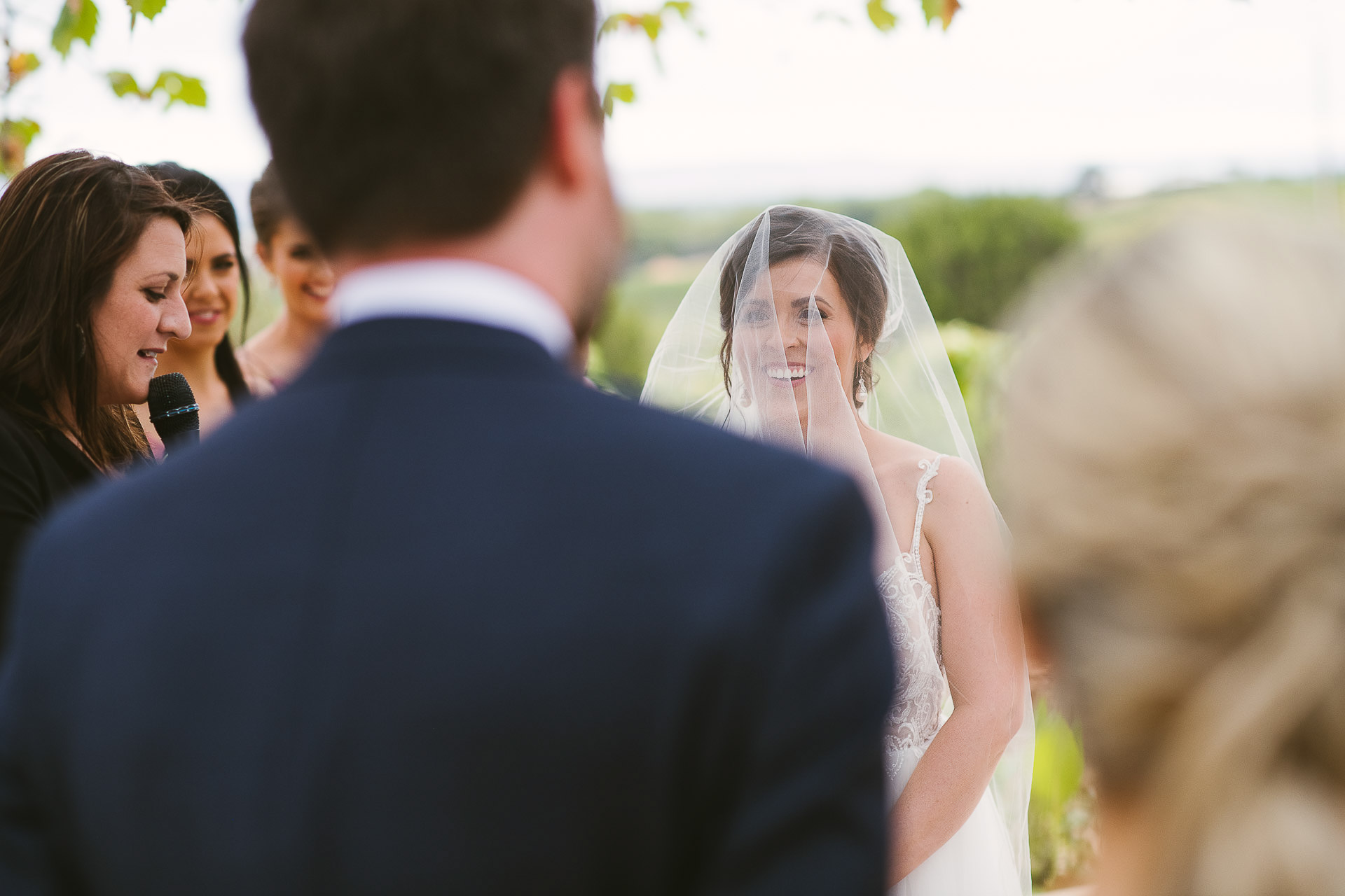 bride smiling over grooms shoulder during wedding ceremony