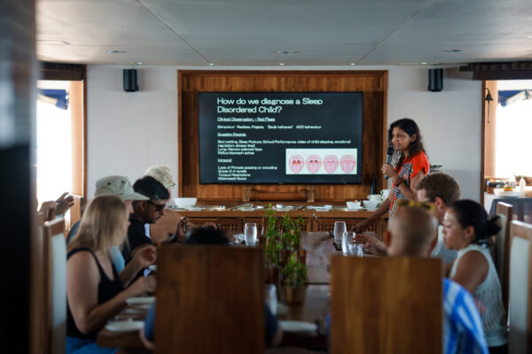 Close-up of presenter delivering keynote slides during liveaboard dental conference