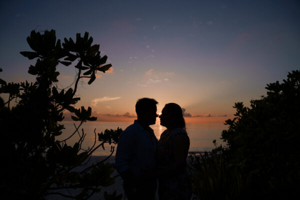 silhoutte of lovers at sunset on deserted tropical island in the Maldives