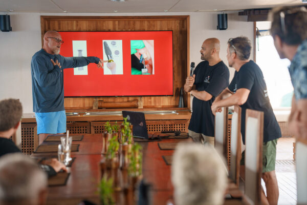 Speakers discussion together while presenting educational seminar to corporate attendees aboard Scubaspa Maldives